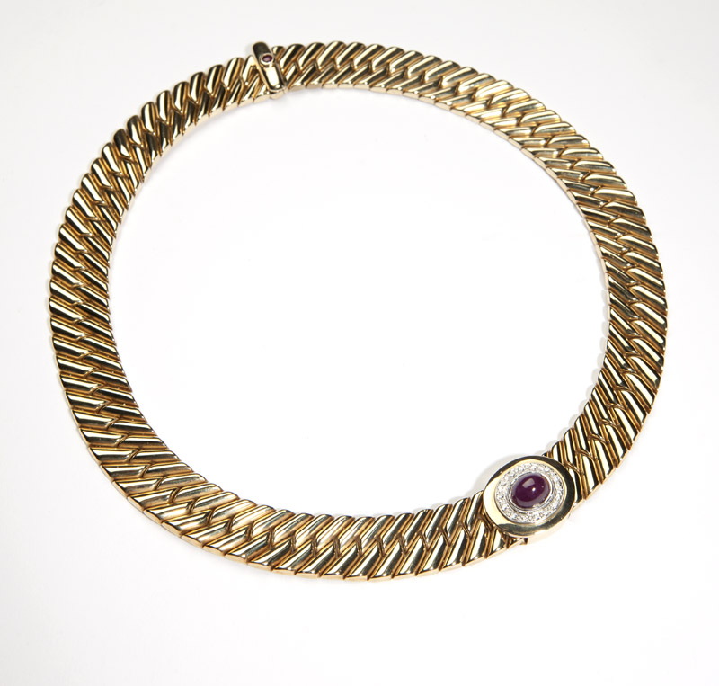 102 A gold wide flat link necklace with ruby slider14K gold, centering an oval ruby cabochon