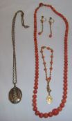 Coral coloured necklace, bracelet and earrings and a locket