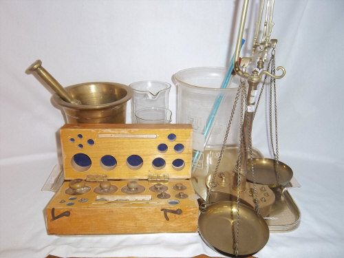 Lg. brass pestle & mortar, pr brass balance scales & weights, sm. brass spring balance, cased set