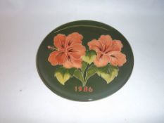 Moorcroft `Hibiscus` plate dated 1986 on green ground