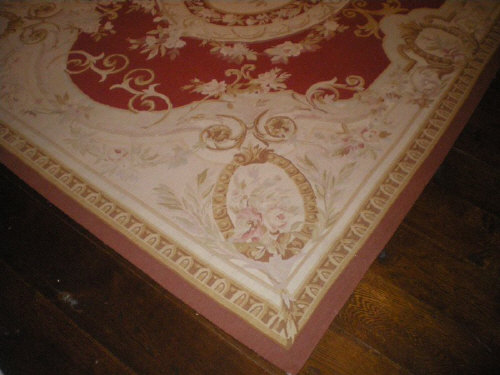 Aubusson design flat weave rug on wine ground with floral cartouches and a bound edge size approx.