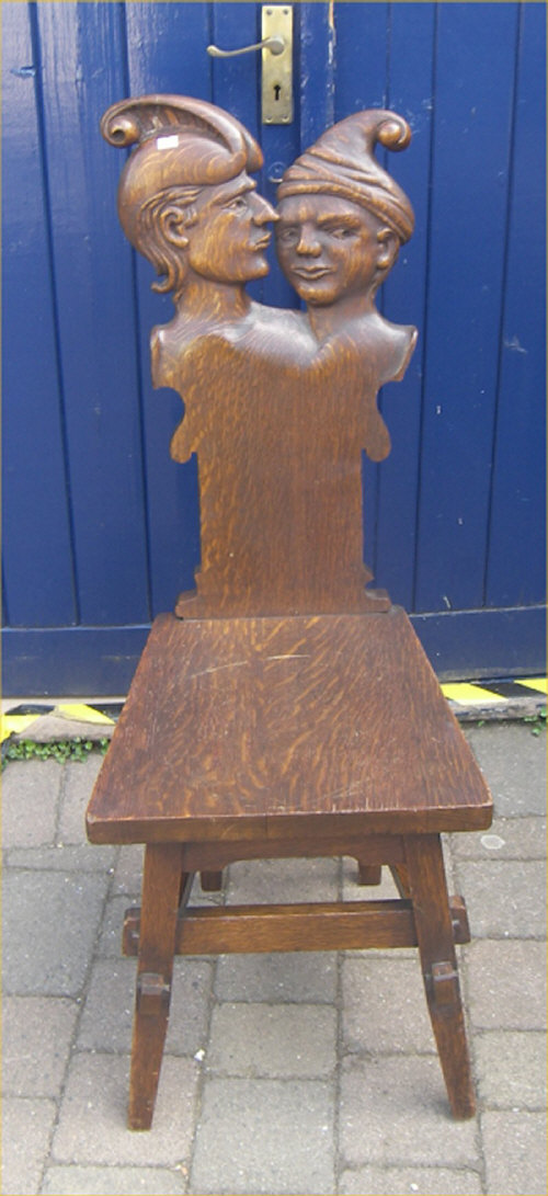 Oak hall chair with decorative carved splat in the form of two heads