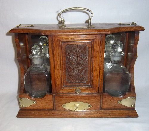 Oak tantalus with 2 glass decanters & central cupboard