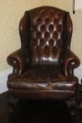 Leather button back wing chair on carved ball & claw feet