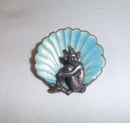 Sterling silver brooch in form of pixie sat in an enamelled shell