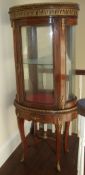 French oval vitrine with gilt metal mounts, single shelf enclosed by bowed door, shaped apron &