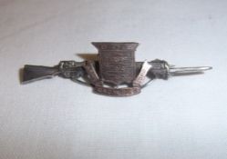 Silver sweetheart brooch in the form of a rifle with central coat of arms `Army Ordinance Corps`
