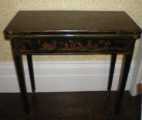 Lacquered fold over card table with Chinoiserie scenes on square tapered legs on brass castors