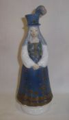 Lladro figurine of a lady wearing a blue dress and feather topped hat