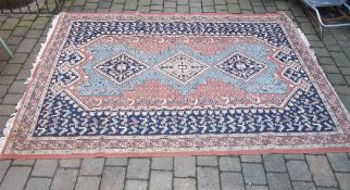 Wool rug on terracotta ground size approx. 275cm x 191.5cm (9ft x 6ft 3in)