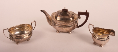 A silver three-piece teaset of Georgian design with composition handle to teapot, 21oz gross