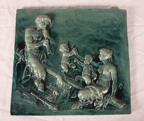 A 19th Century pottery panel decorated in high relief with fauns in turquoise glaze, 13" wide