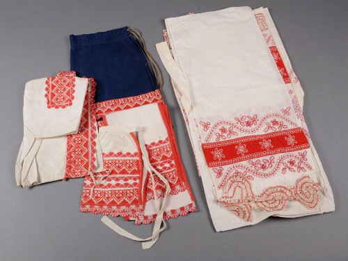 A Russian embroidered set of blouse, apron and scarf with red and white bobbin lace edging and a