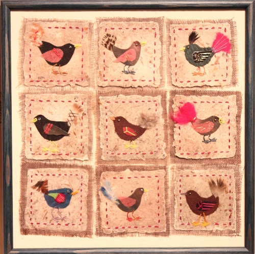 A modern appliqué panel, nine various birds, in blue strip frame