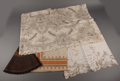 A linen tablecloth completely covered in Madeira embroidery, cutwork and needlelace, another with