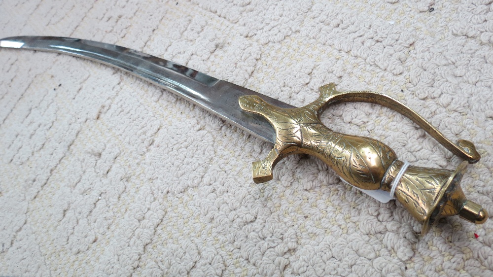 An Indian made scimitar with brass hilt, scabbard deficient.  Blade length 62cm.