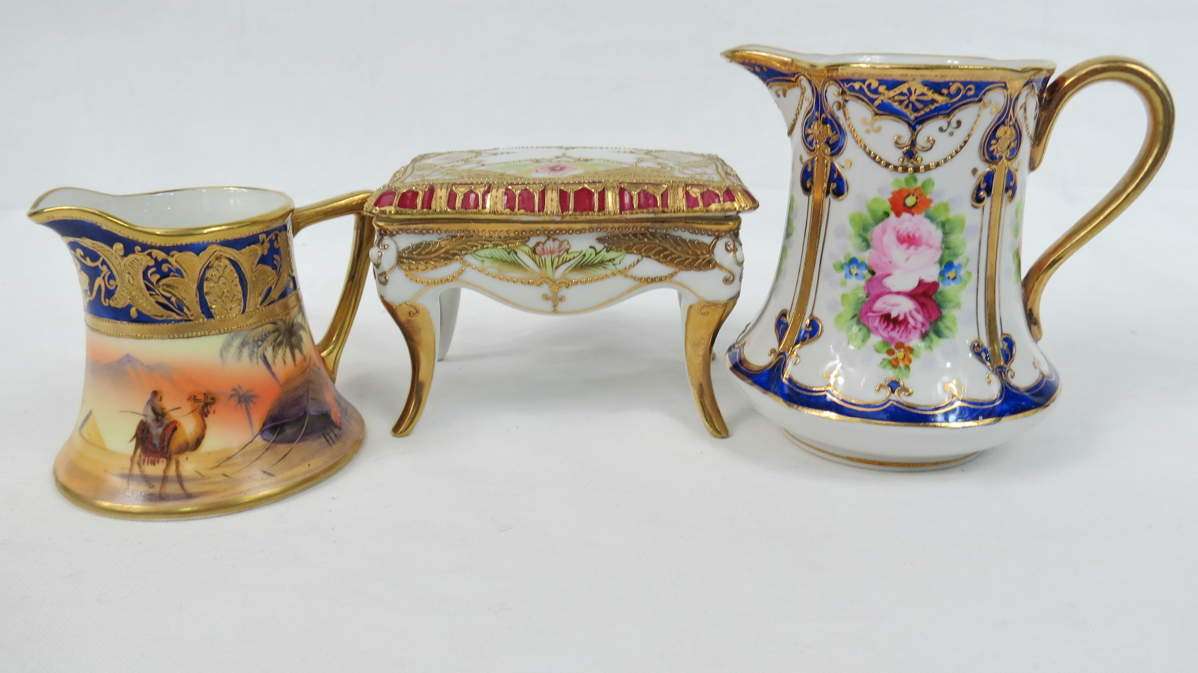 Three Noritake porcelain items including a casket raised upon four legs, a cream jug with rose