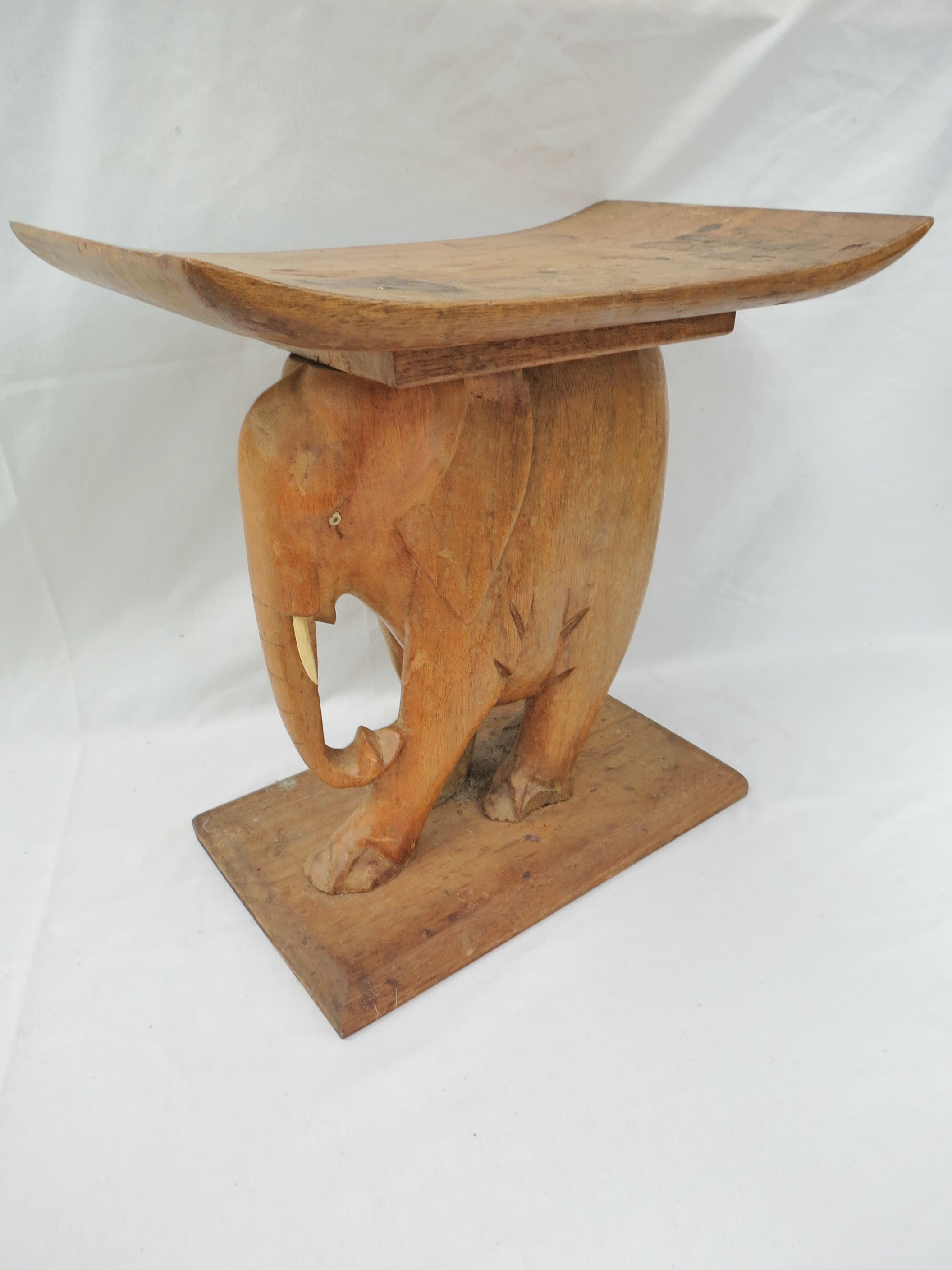 A Kenyan man's stool seat with elephant support. 38cm wide.