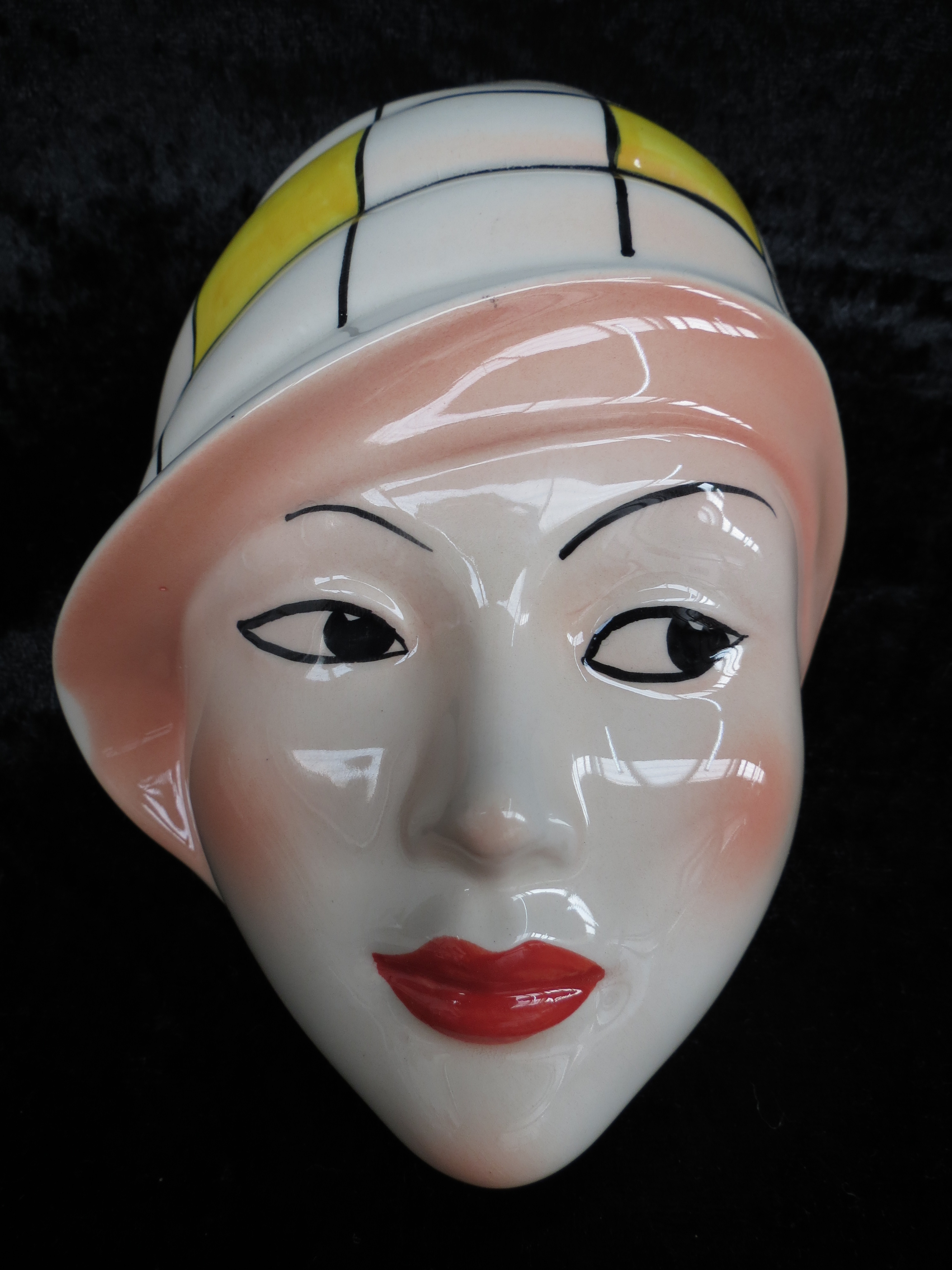 A Crown Devon wall mask the moulded form painted by Dorothy Ann.