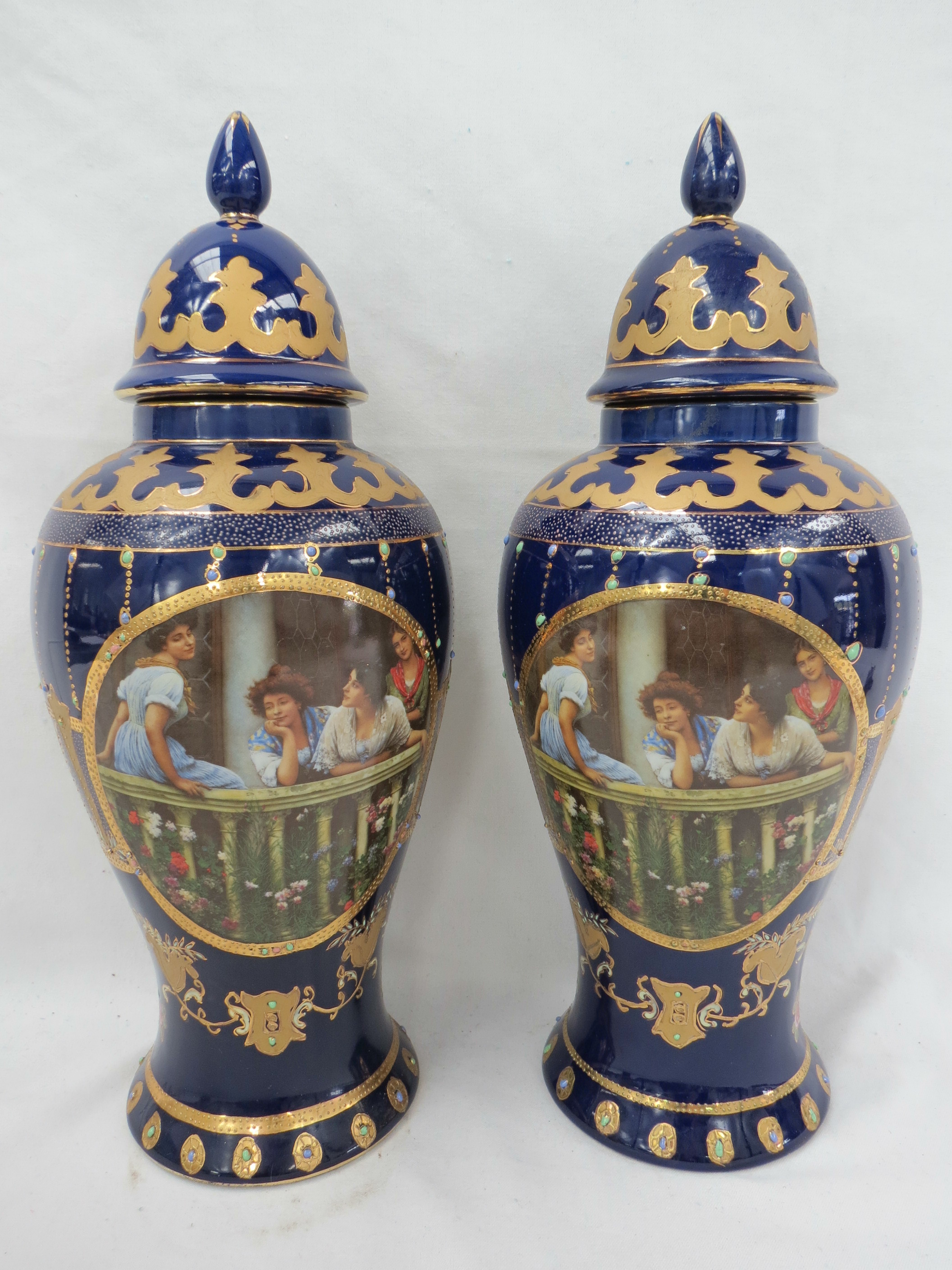 A pair of early 20thC continental lidded baluster shaped vases, printed with a vignette of ladies on