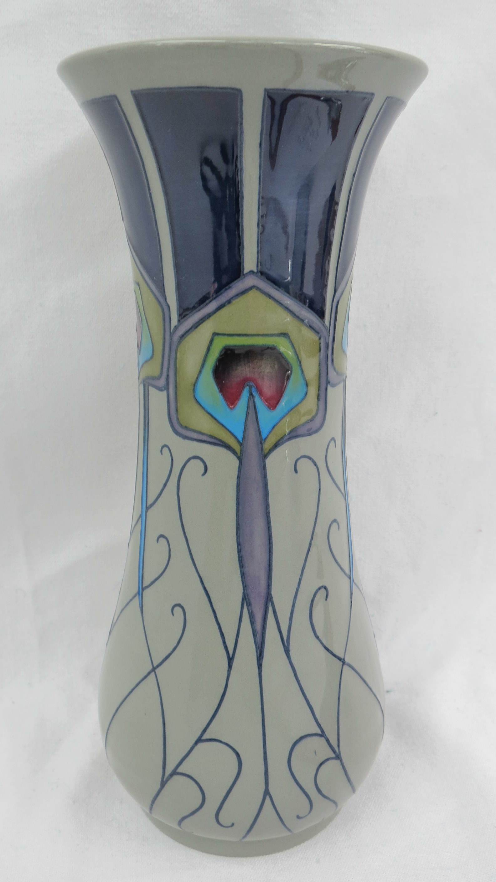 A Moorcroft baluster shaped vase, decorated with a stylised peacock feather design on a green/grey