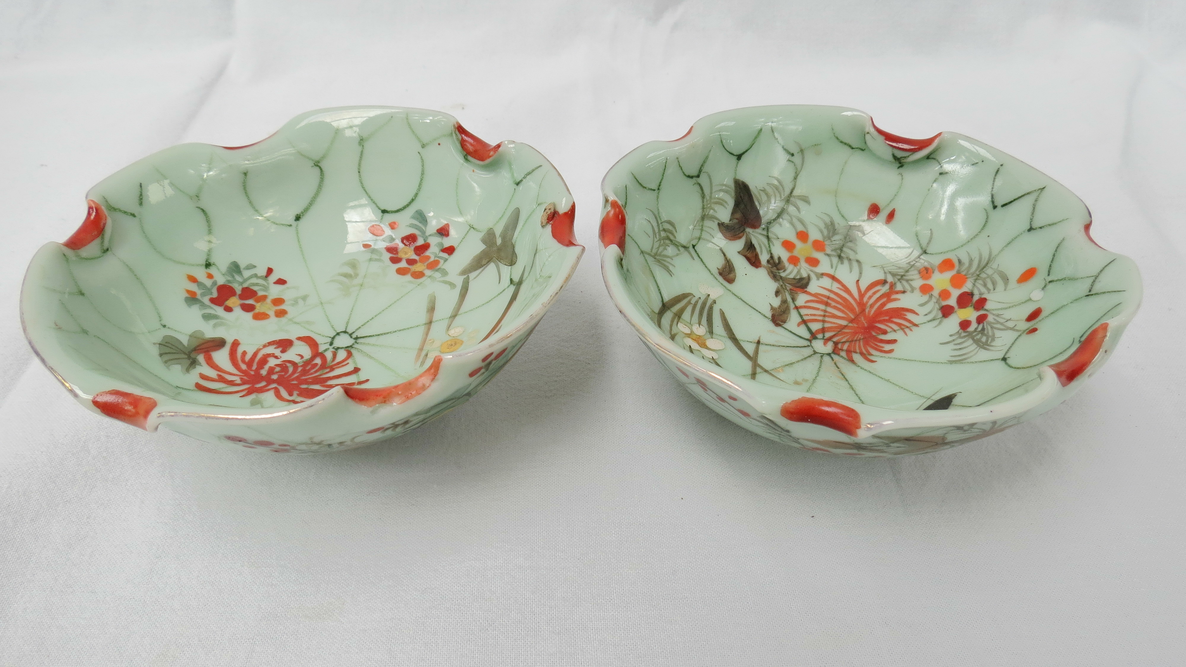 A pair of porcelain oriental bowls with hand painted flowers on a celadon ground, 10.6cm dia.