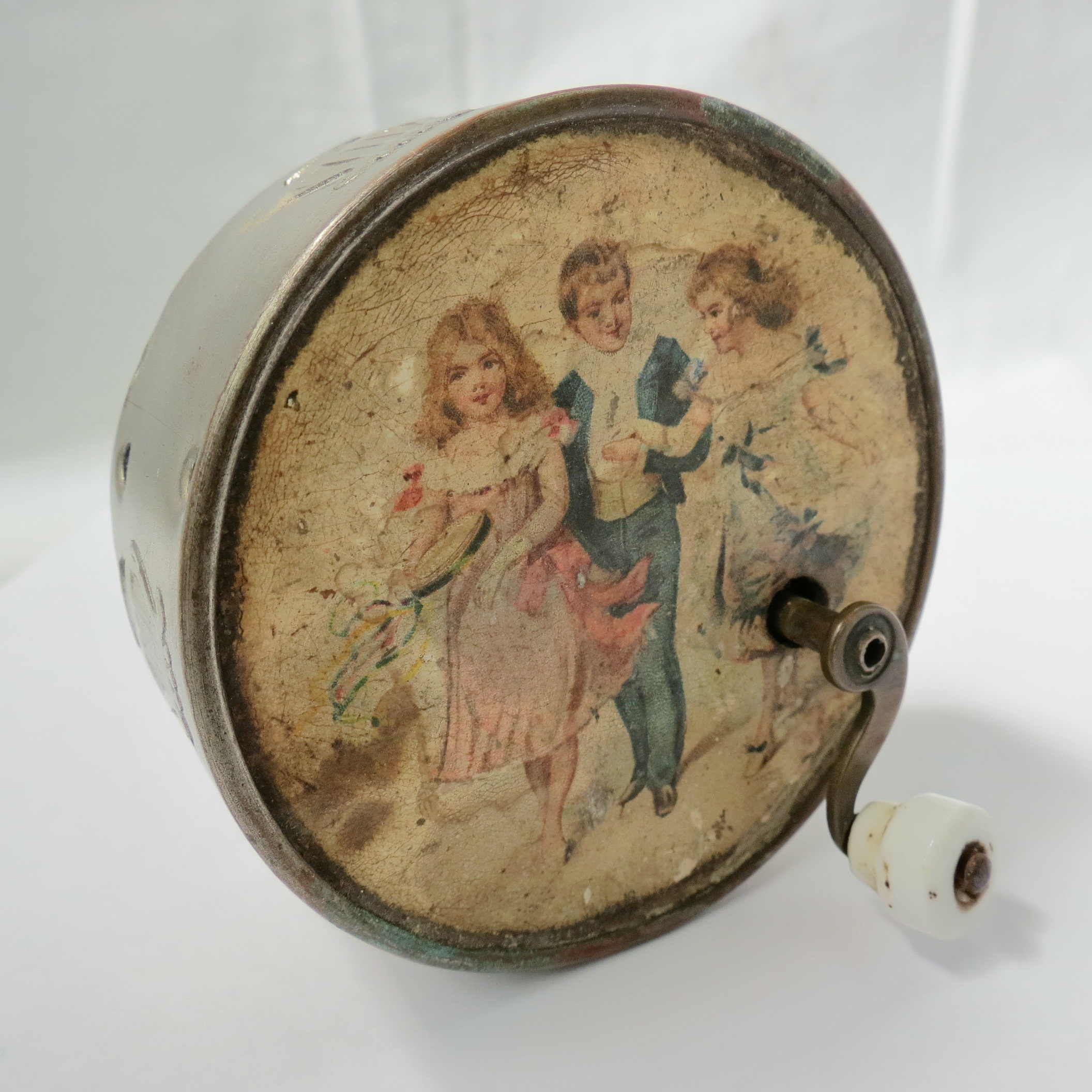 A late Victorian musical box, of circular form, the top with a lithograph of young man with two