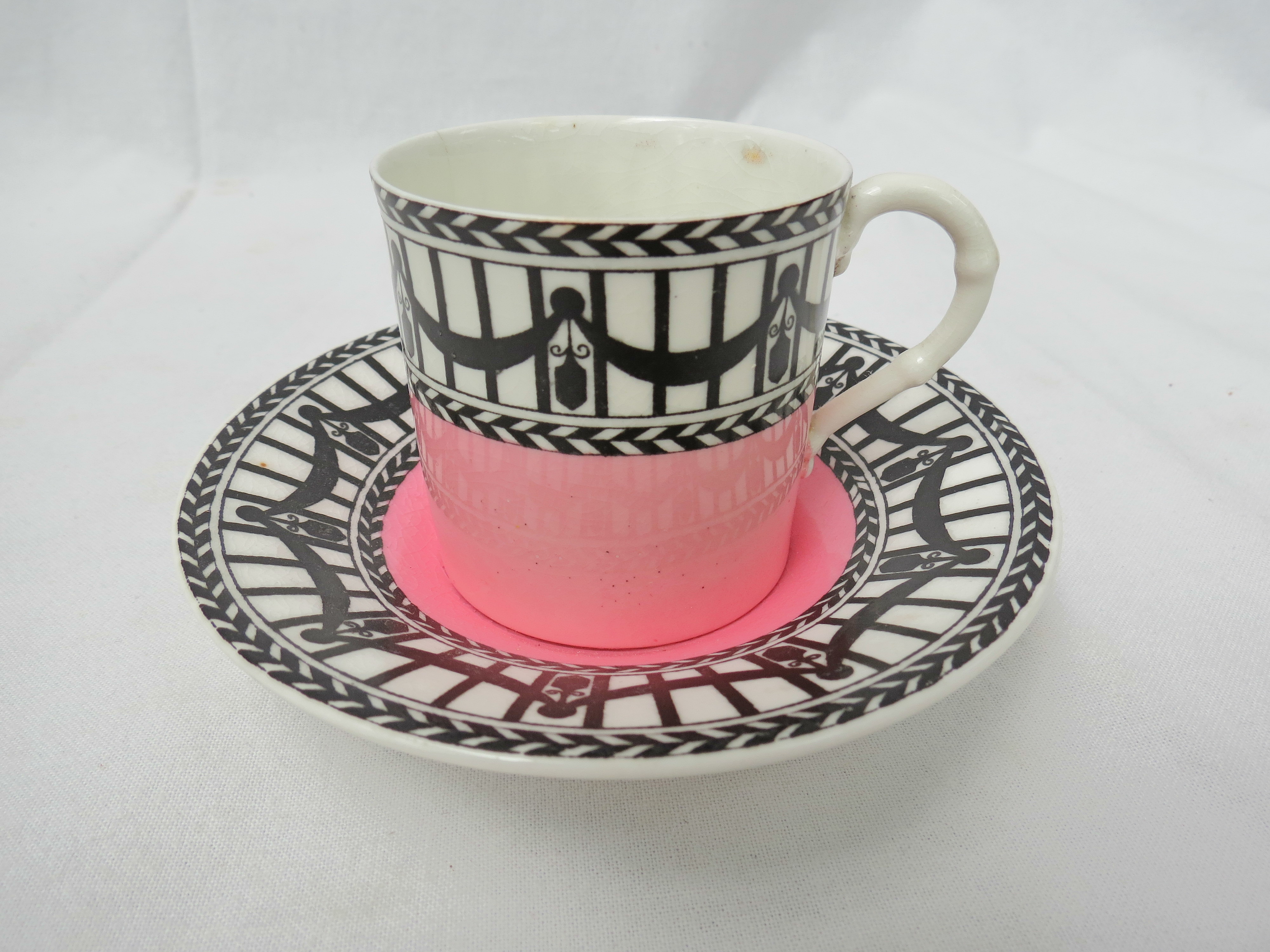 A Royal Worcester coffee can (5cm high) and saucer (10.8cm  dia) having black swags on a white
