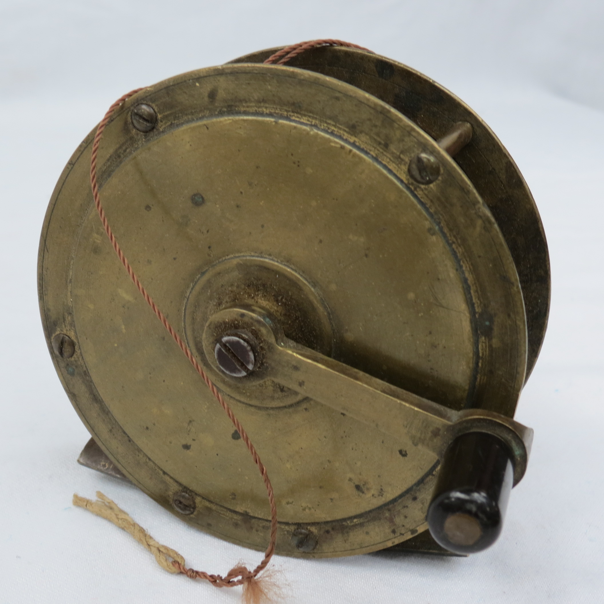 An early 20thC brass fly fishing winch 4", the foot plate bearing the number '6'.