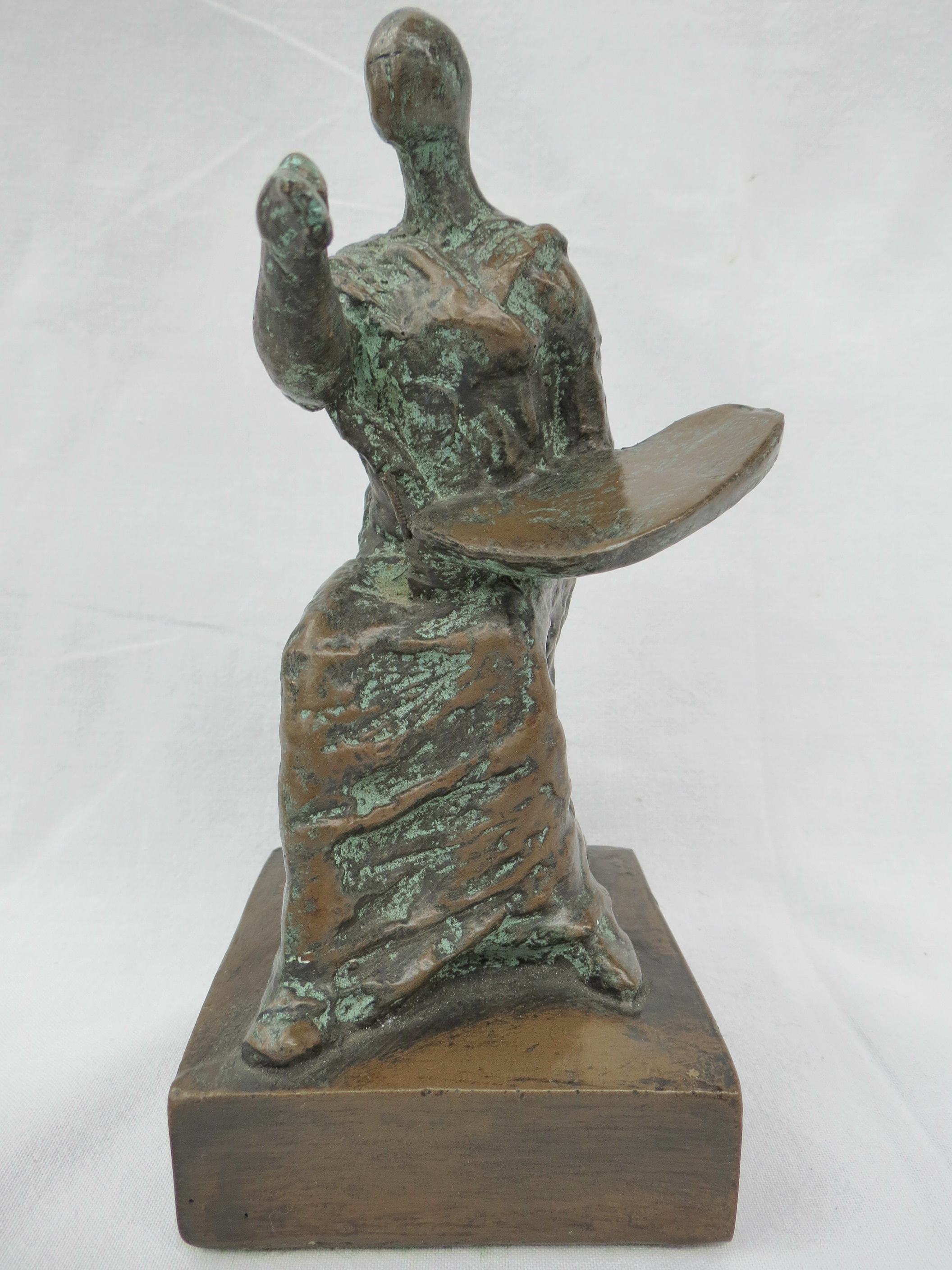 After Henry Moore.  Draped artist, seated holding a pallet patinated cold cast bronze. 17cm high.