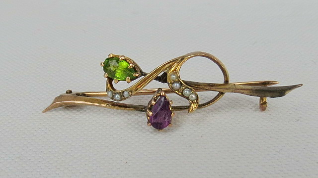 A peridot/amethyst and seed pearl bar brooch,m stamped 9ct.