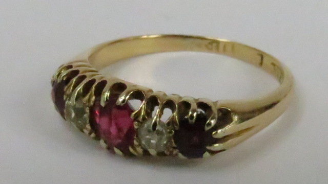 An 18ct half hoop curved head dress ring, three rubies, one old cut diamond and one white paste