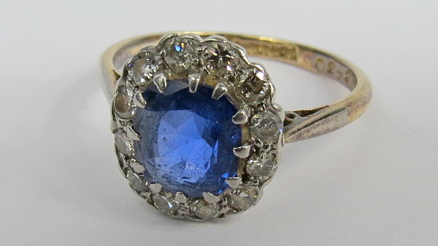 A cushion shaped sapphire and diamond ring, rich blue sapphire suggests Sri-Lanka origin, surrounded