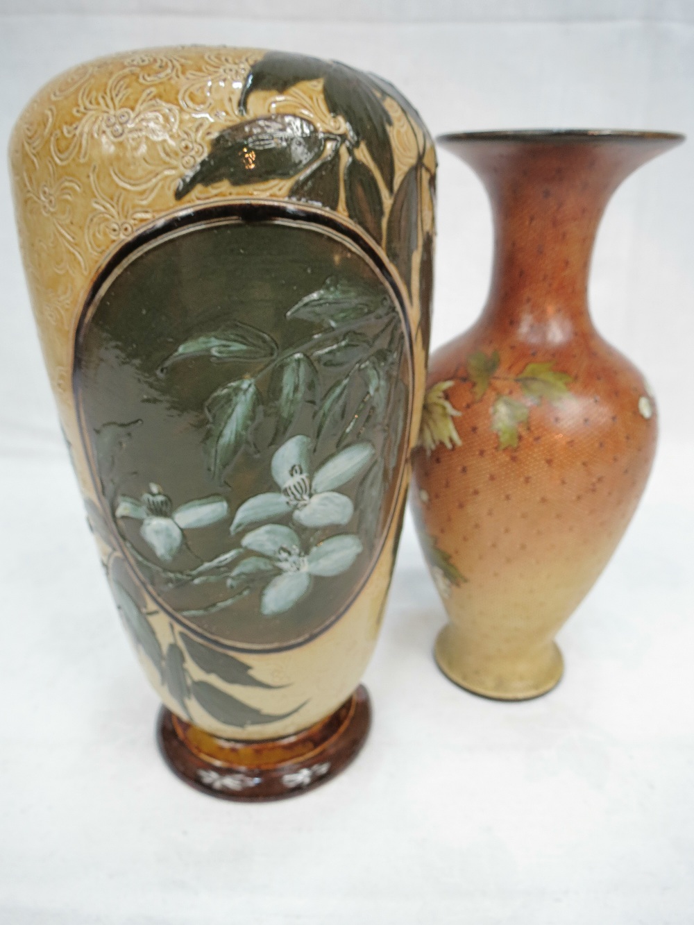 An early Doulton Stoneware vase decorated with a bird and another decorated with flowers.