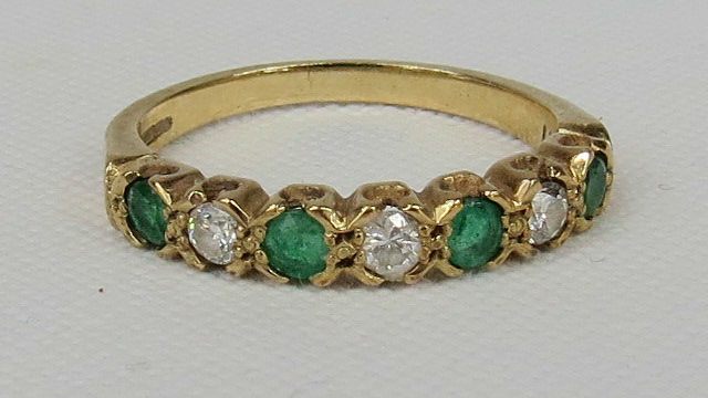 A 9ct diamond and emerald half eternity ring.