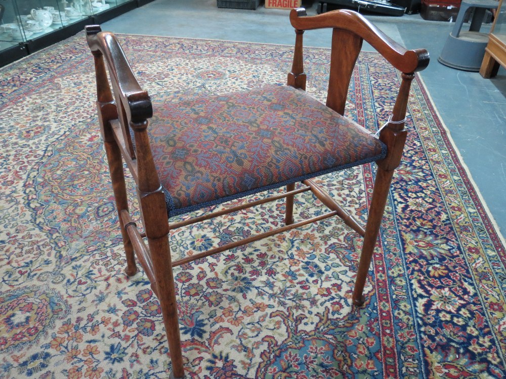 A good mahogany piano stool of art nouveau influence, having padded seat raised over tapering turned