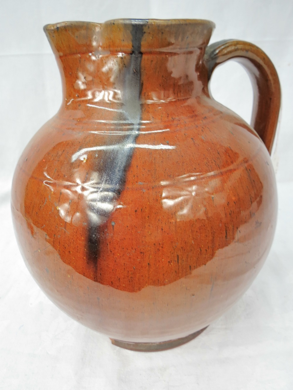 A large hand-thrown jug in terracotta with clear glaze, 10.5" high.