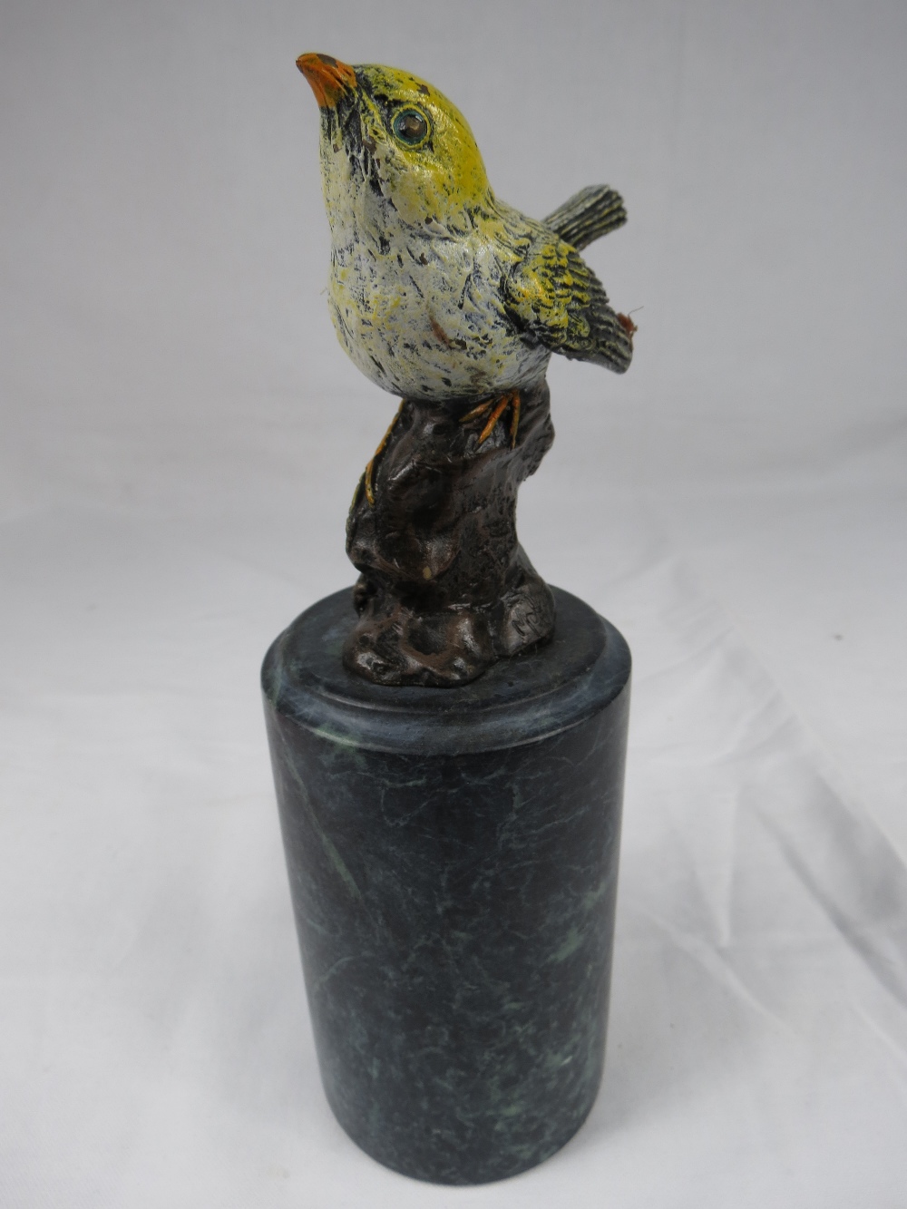 A gold painted cast bronze figure of a bird on a heavy marble base.