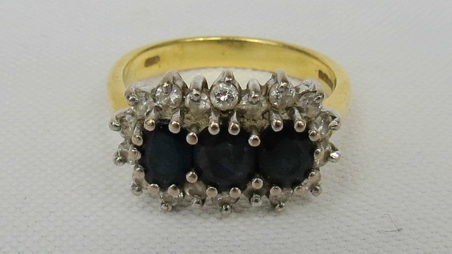 A heavy 18ct gold sapphire and diamond triple cluster ring, three oval sapphires surrounded by a