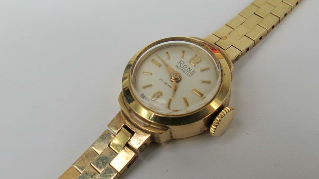 A ladies 9ct bracelet watch, round white dial, gilt batons and hands, polished brick bracelet.