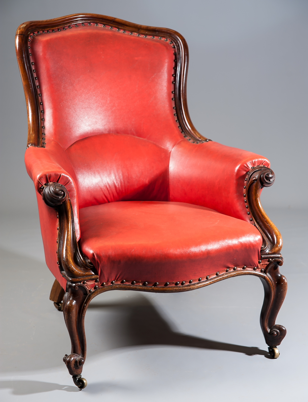 A Victorian mahogany show frame armchair of generous size, on carved cabriole forelegs.