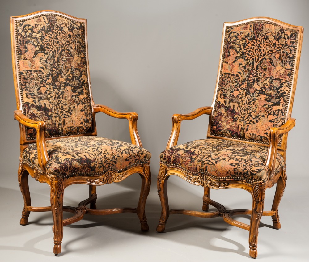A pair of Continental style carved walnut high back armchairs, each with cabriole legs united by