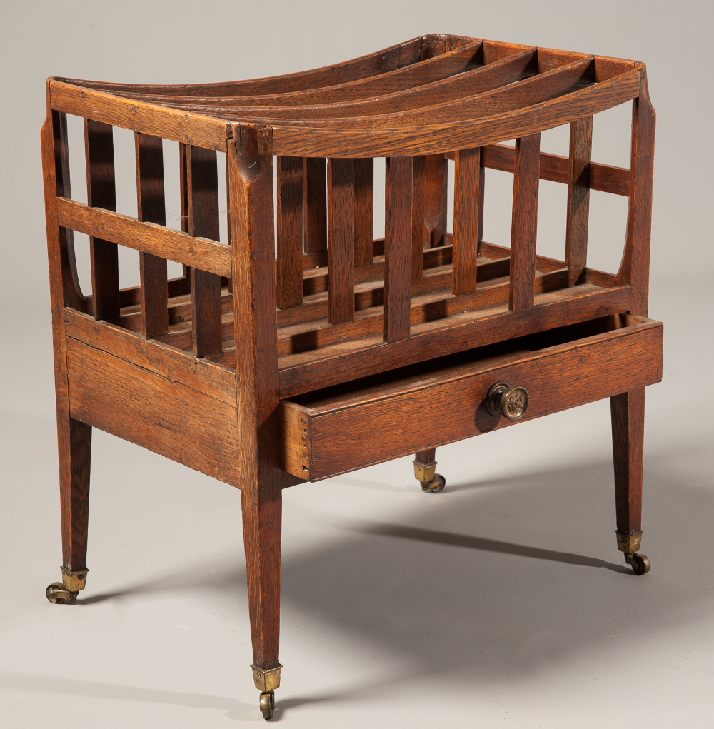 A Regency oak Canterbury, with frieze drawer, on straight tapering legs and brass castors.