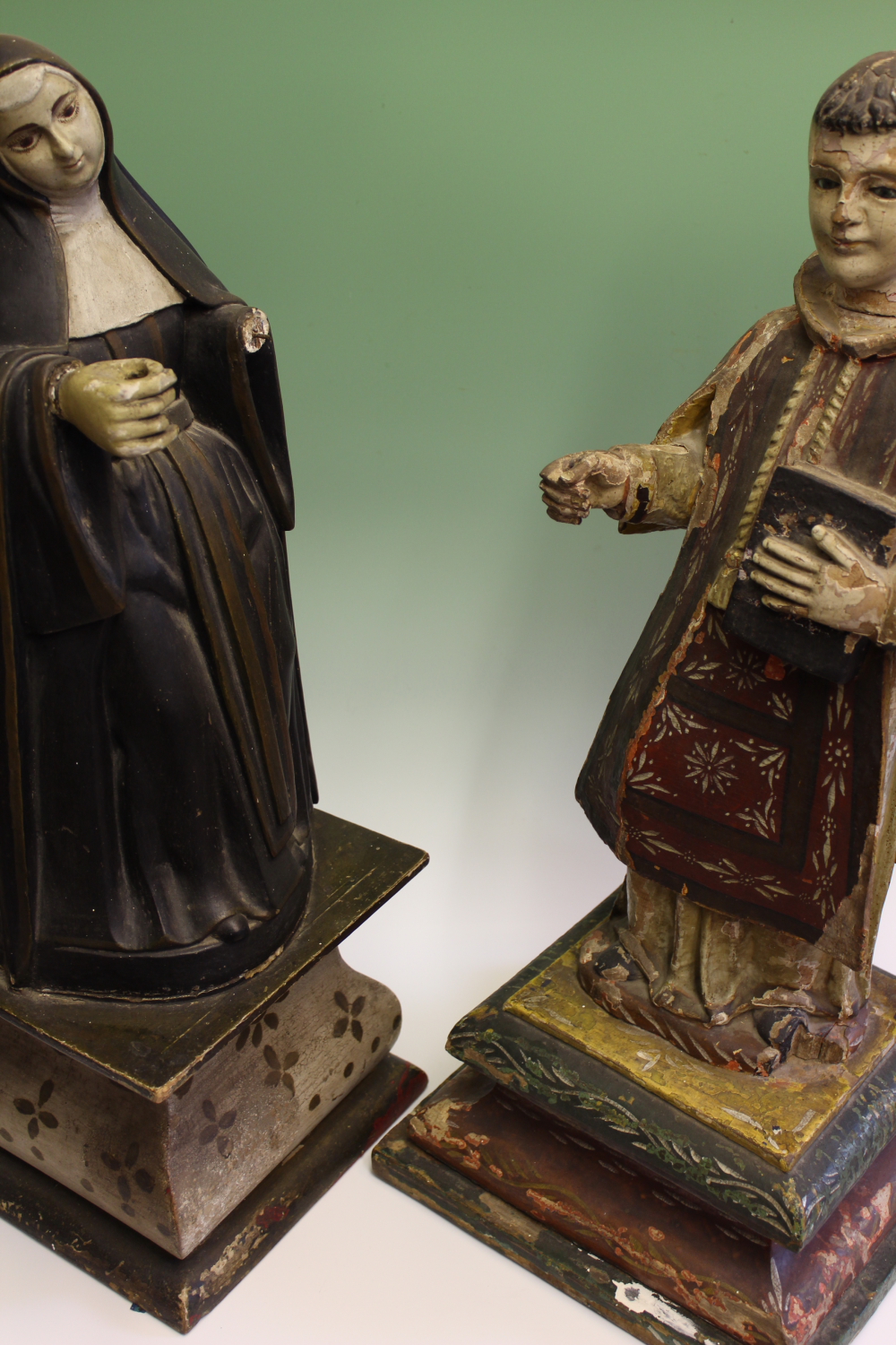 Two early Spanish painted and carved wood figures of a nun and a saint, she in black and white robes