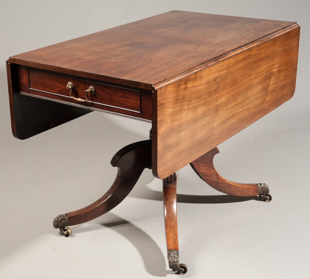 A late Georgian mahogany drop leaf pedestal library table, on fluted sabre legs, 100cm wide.