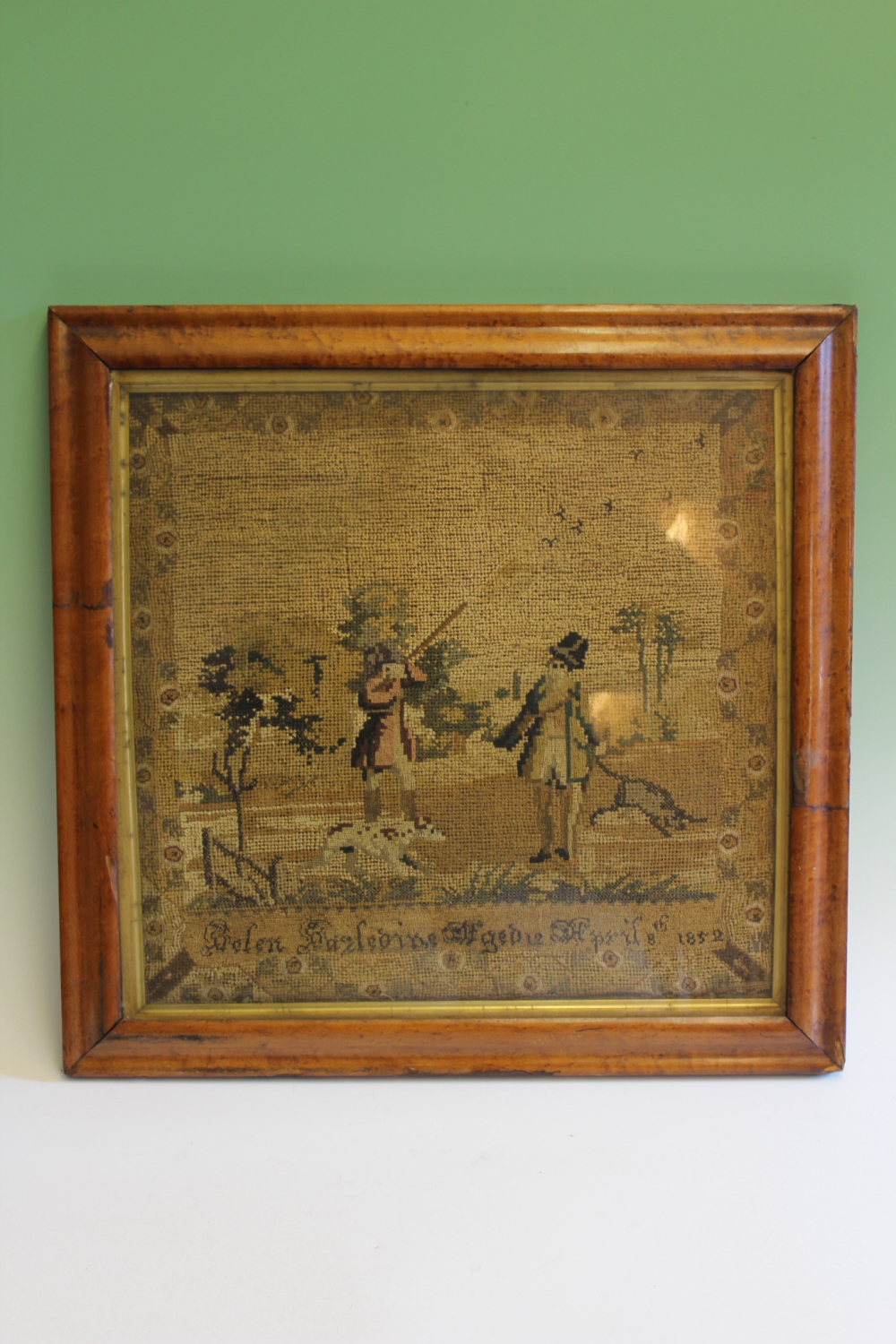 A 19th Century pictorial sampler depicting gentlemen out shooting with gun dogs, by Helen Hazledine,