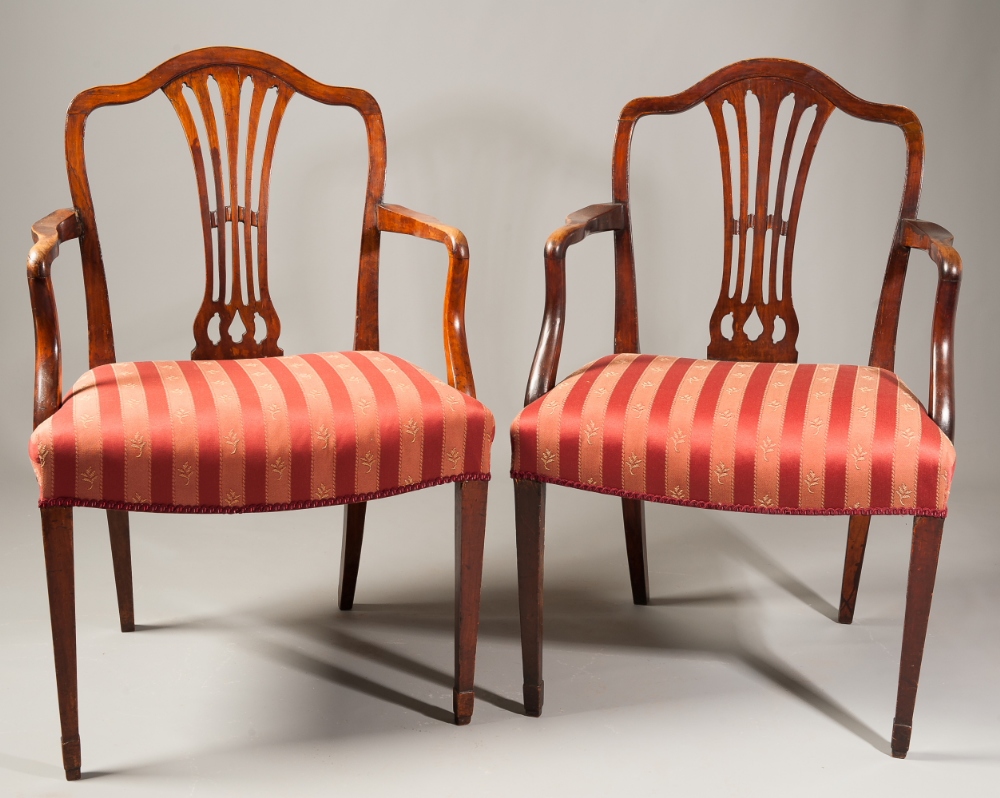 A pair of George III mahogany chairs, with pierced splats, saddle shaped seats, on straight