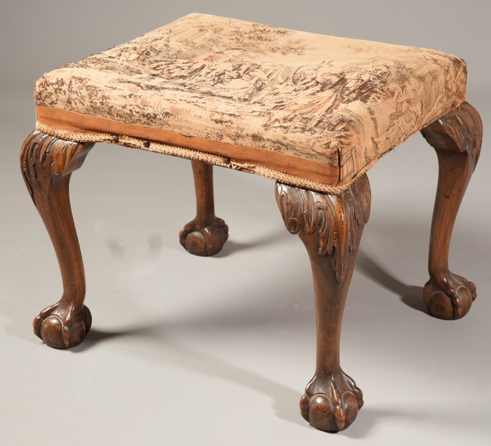 A George III style carved walnut dressing stool, on claw and ball feet.