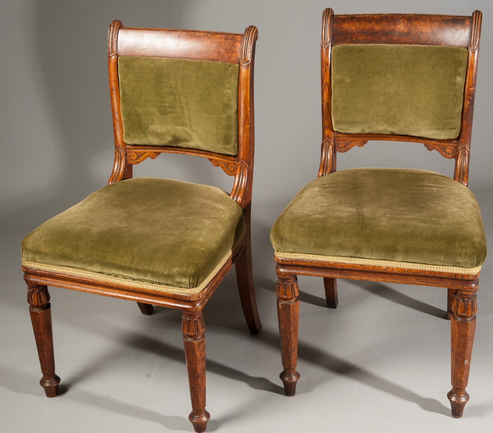 A pair of William IV carved oak chairs, with burl crest rails, on facetted tapering legs. (2)