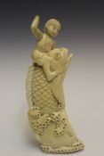 A Japanese carved ivory figural group, depicting a boy on a leaping carp, 20cm high.